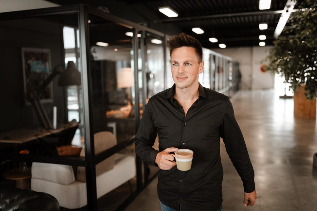 Skrepr collega met koffie op weg in kantoor